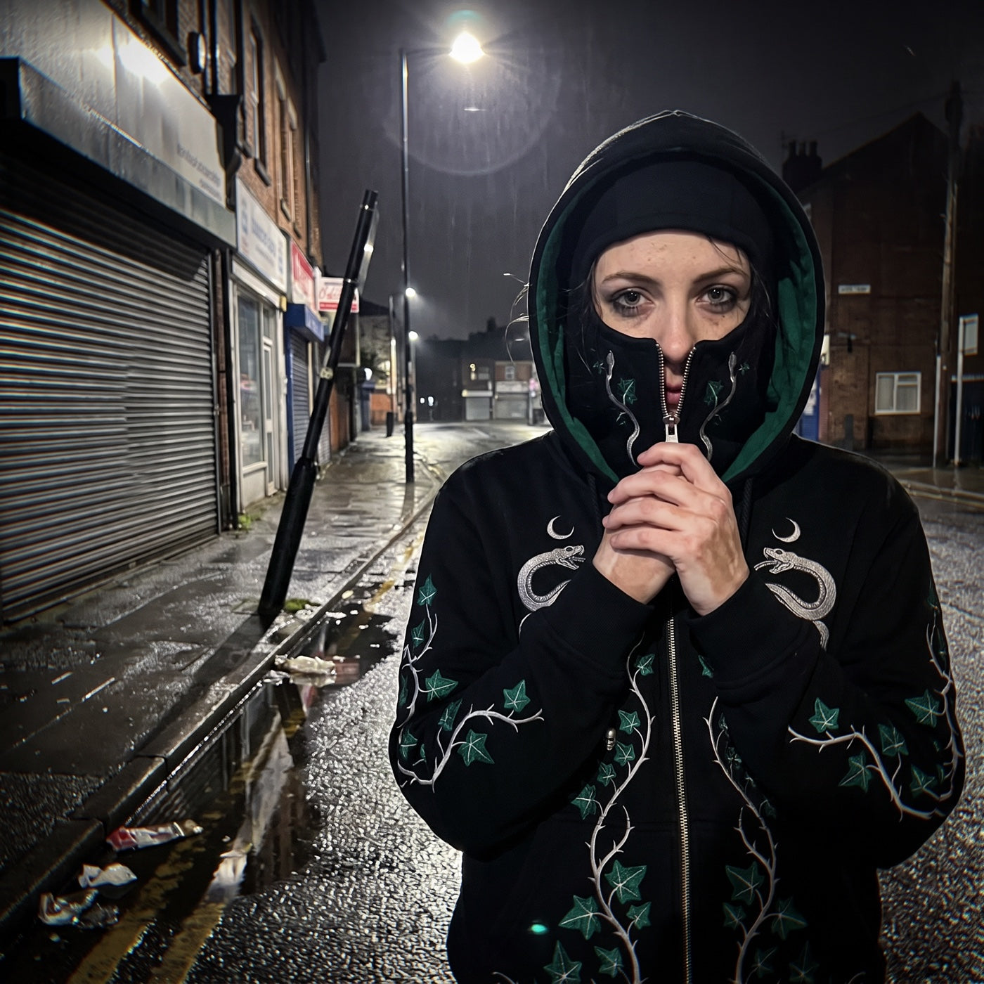 Zipped to the eyes on a wet street at night